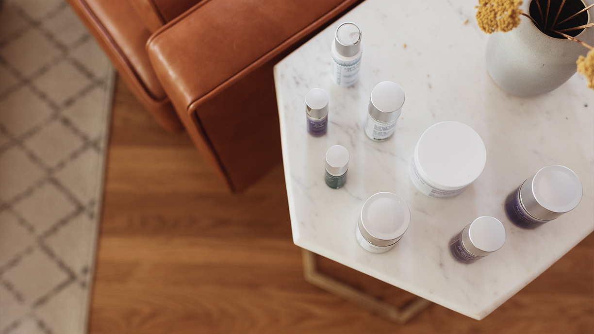 A set of Skin Script products sitting on a marble table.