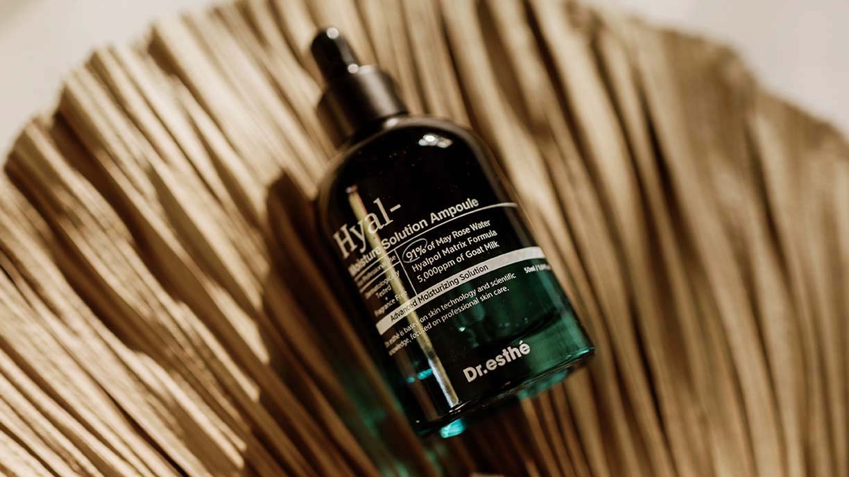 Dr. esthé Hyal- Moisture Solution Ampoule laying on a dried palm leaf